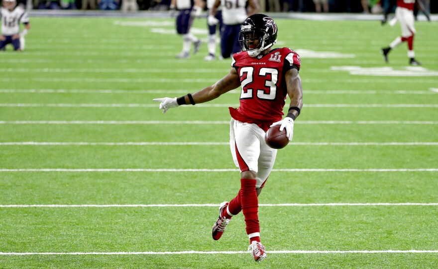Falcons defensive back Robert Alford scores an 82-yard touchdown after picking off a pass by Patriots quarterback Tom Brady. The score gave the Falcons a daunting lead.