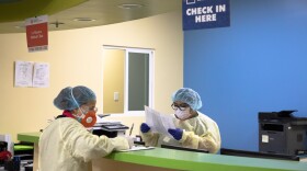 Healthcare staffers at La Maestra Community Health Centers’ City Heights clinic work in an area that has been temporarily converted to receive patients who have COVID-19 symptoms, April 8, 2020.