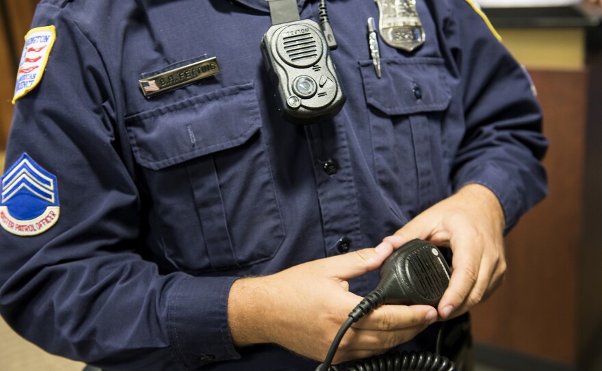 D.C. Master Patrol Officer Benjamin Fettering shows a body camera worn in place of a normal radio microphone before a news conference in 2014.