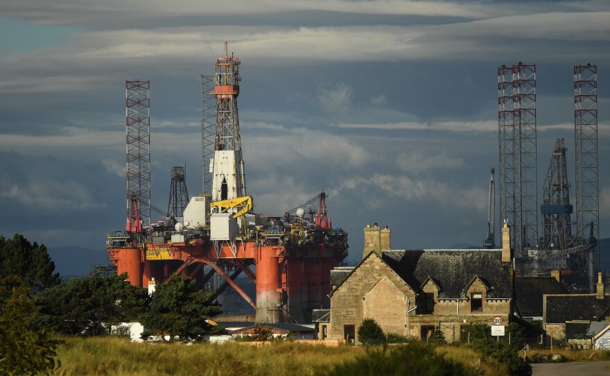 An oil rig towers over houses in Nigg, Scotland, on September 8. Major players in the oil industry expect depressed oil demand and low prices to continue well into next year.