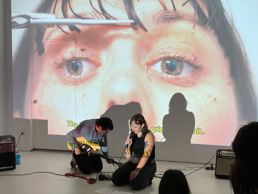 Poet Lora Mathis and musician Matty Terrones perform against a projected backdrop of Mathis' visual poetry and film stills on Sept. 17, 2021.