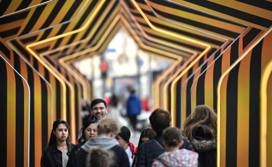 People walk through a tunnel of stars set up as decoration for Russia's Victory Day in central Moscow on Thursday. Russia will hold an annual military parade at Red Square on May 9.