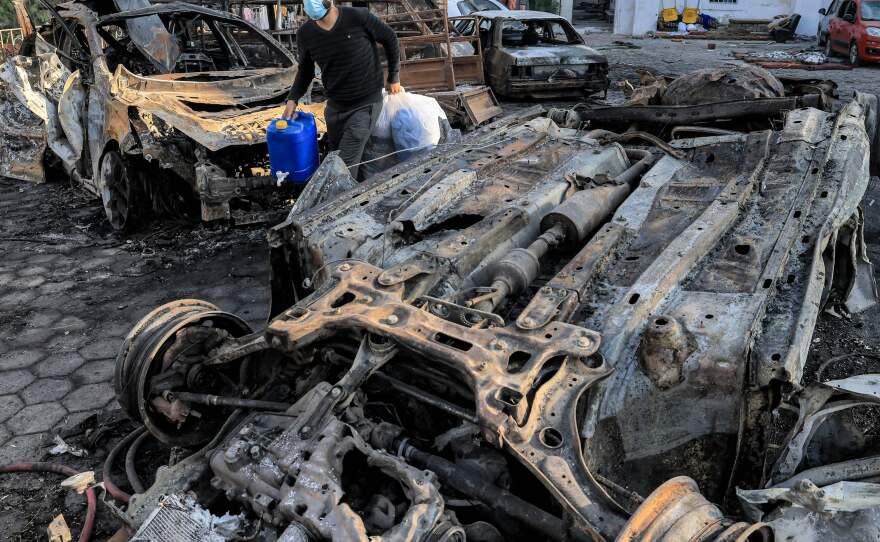 A man walks past destroyed vehicles at the site of the Ahli Arab hospital in Gaza where an explosion killed hundreds of people, sparking global condemnation and angry protests around the Muslim world.