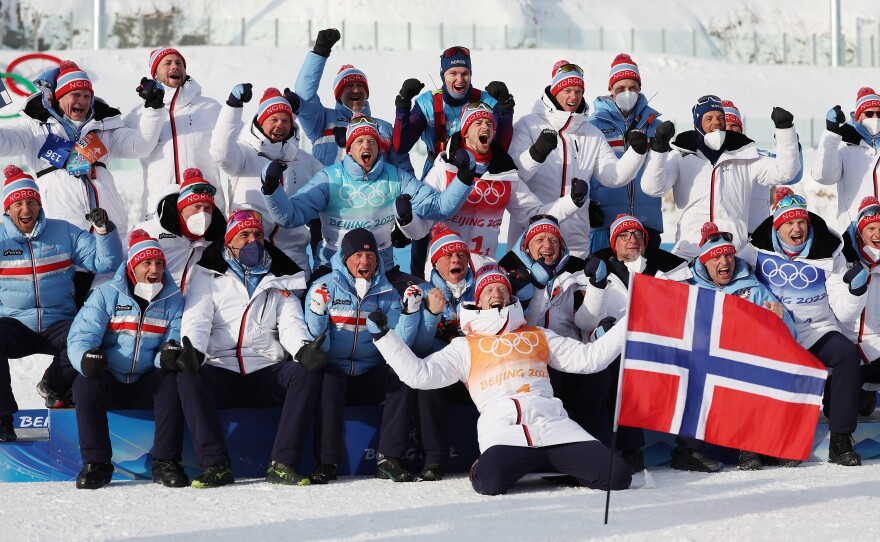 Gold medallists Tarjei Boe, Sturla Holm Laegreid, Johannes Thingnes Boe and Vetle Sjaastad Christiansen of Team Norway celebrate with their team and staff during Men's Biathlon 4x7.5km Relay flower ceremony on February 15, 2022 at the Beijing Winter Olympics.