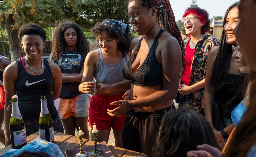 Kenya, Zohara, Maia, Satya, Ollie, Natalie, and Kaila say Hebrew prayers while lighting the Shabbat candles on Friday evening.