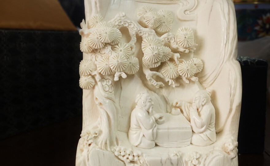 An ivory carving made from a piece of scrap by an apprentice of carver Li Chunke shows two men playing Go under a pine tree.