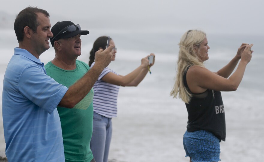 People take photos of the sea in Los Cabos, Mexico, on Sunday ahead of Hurricane Odile's landfall.