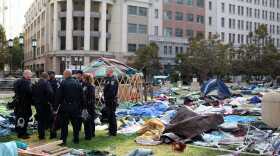 Oakland police officers stand in the remains of the Occupy Oakland camp after police shut the encampment down on October 25, 2011 in Oakland, California.
