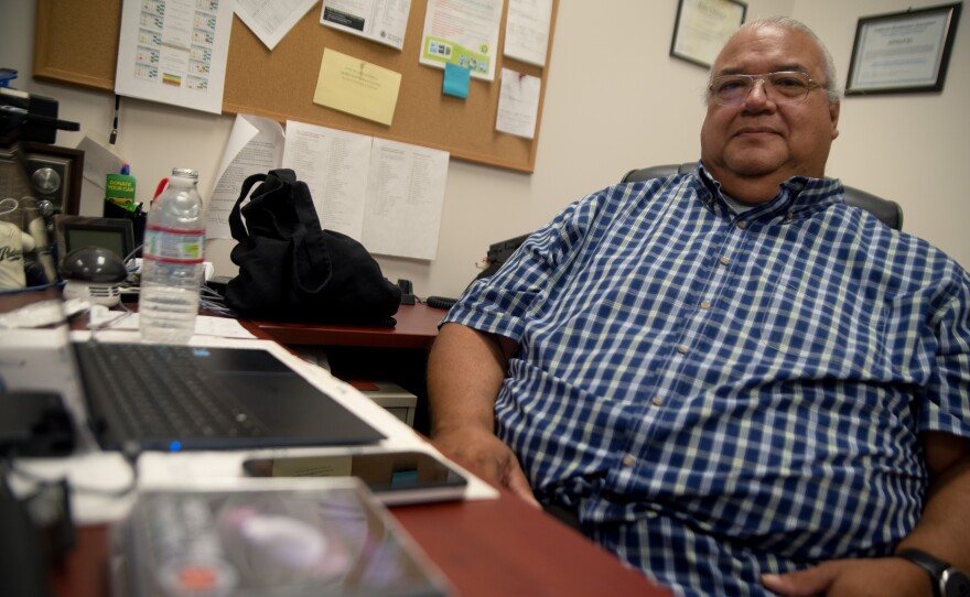 Eric Ortega sits at his desk inside Pala Rez Radio, in front of him is a stack of CD's with a local musician's flute music that will be archived at the station on Thursday May 29th, 2025.