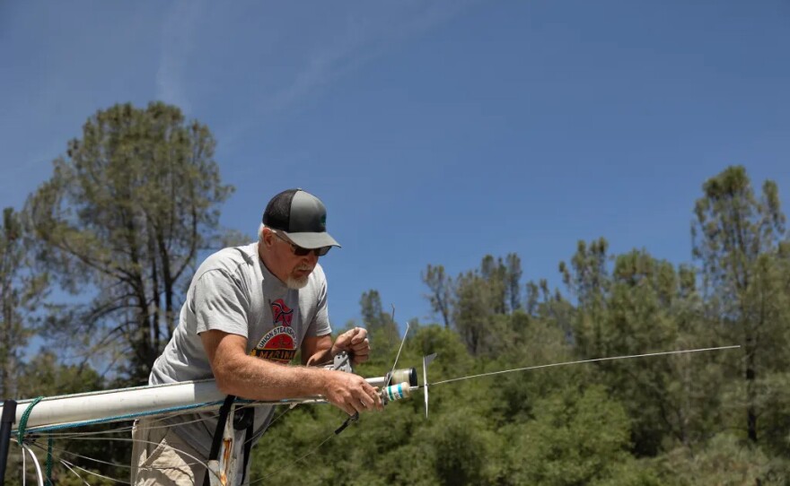 Dean Dyrr prepares his sailboat at Lake Oroville. He said inspectors spotted mussels on the boat next to his.