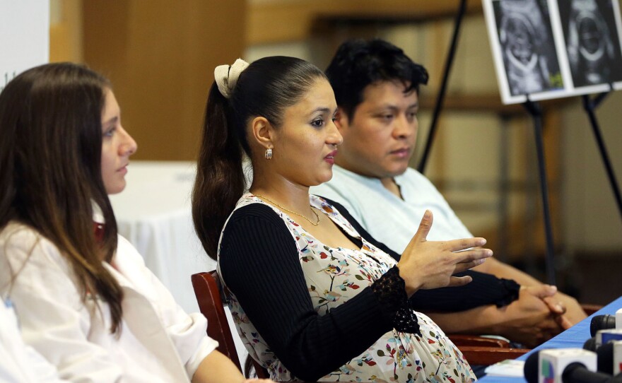 Yessica Flores (center), who became infected with the Zika virus early in her pregnancy this summer, told Miami reporters this week about her worries. The fetus looks healthy, so far, doctors say. Flores and her husband Selvin Yac (right) have already named the baby — Daniela Elizabeth.