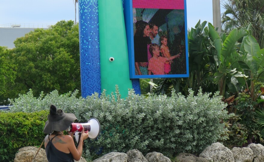 Activist Michelle Morrow tries to convince visitors to turn around at the entrance to the Seaquarium