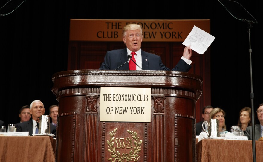 Donald Trump holds up notes as he speaks to the Economic Club of New York on Thursday.
