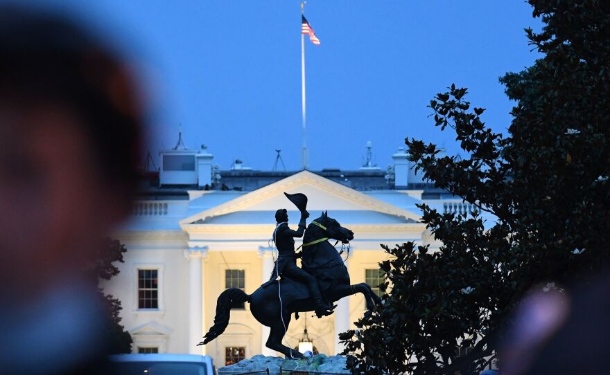 Police officers stand guard with the statue of former President Andrew Jackson after protesters tried to topple it Monday in Lafayette Square in Washington, D.C.