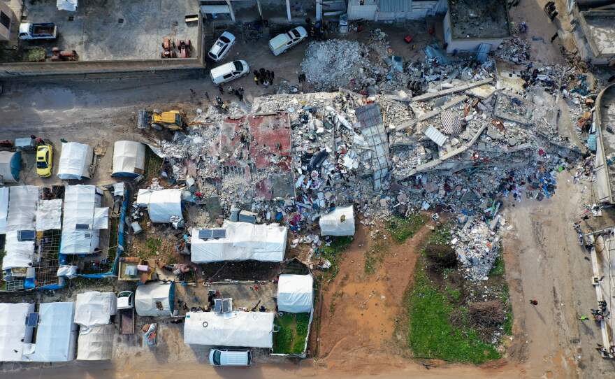 An aerial view shows rescuers searching the rubble of buildings for casualties and survivors in the village of Azmarin in Syria's rebel-held northwestern Idlib province on Tuesday.