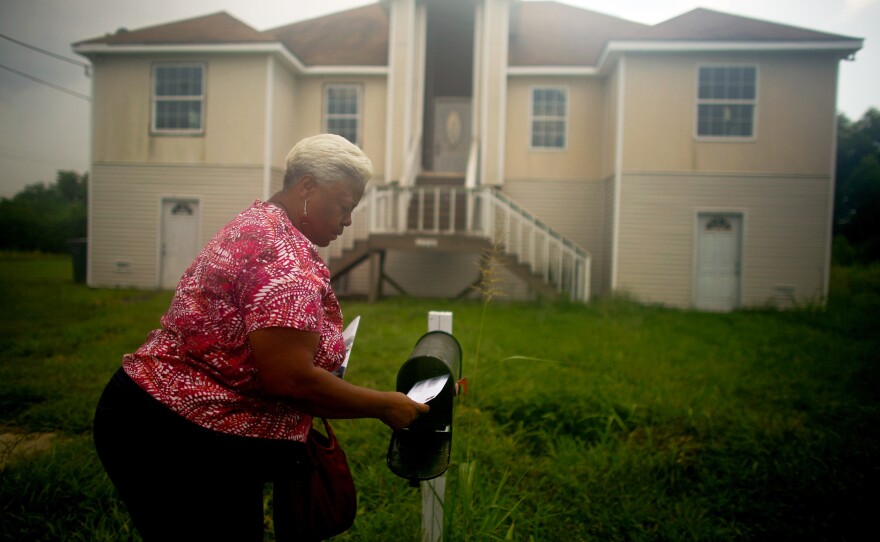 Bobbie Banks collects mail at her home, which she struggled to rebuild and still cannot occupy. Her first contractor took $105,000 of her money, but didn't finish the work. Then she had to rip out toxic drywall that another contractor used.