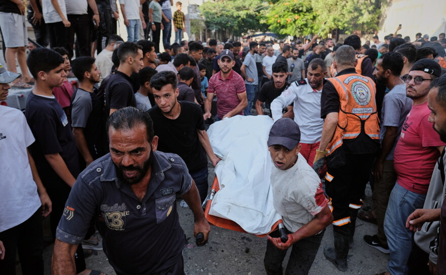 Palestinians carry a body from the site of an Israeli military strike in Gaza City, Sunday, Aug. 2, 2026.