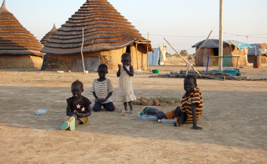 <p>Children in South Sudan, one of the world's poorest nations, sit in front of traditional homes made of mud and thatch.</p>