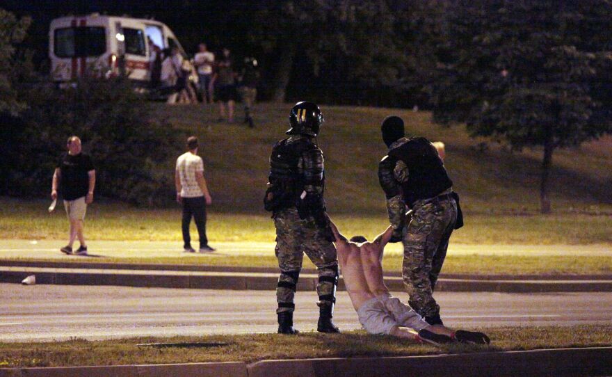 Riot police detain a protester after polls closed in the presidential election, in Minsk in Aug. 2020.