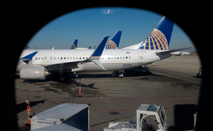 In this Nov. 22, 2017, file photo taken through an aircraft passenger window, United Airlines planes are parked at a terminal at O'Hare International Airport in Chicago.