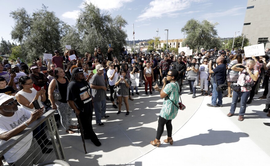 Christina Griffin, center, speaks to a crowd of protesters in front of the El Cajon Police Department, Sept. 28, 2016.