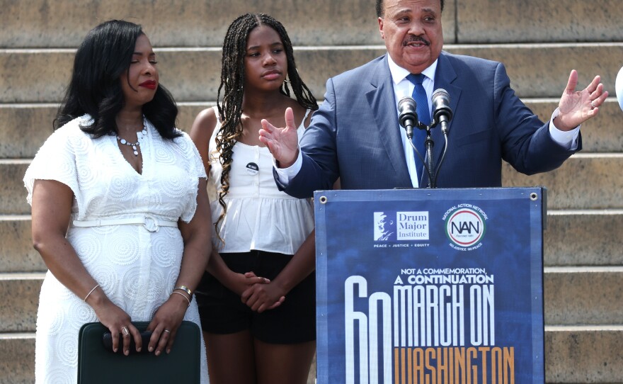 Civil rights activist Martin Luther King III, joined by his daughter Yolanda King (center) and wife Arndrea Waters King, delivers remarks at Saturday's rally in Washington, D.C.