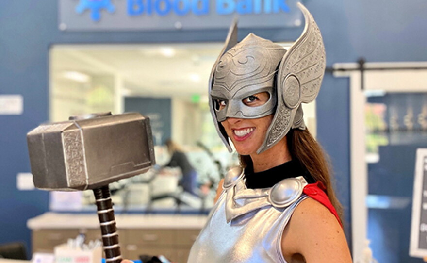 A woman dressed as Lady Thor poses before the San Diego Blood Bank logo in this undated photo.