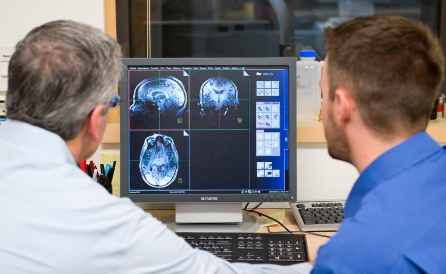 Jeffrey Iliff (right) and Bill Rooney, brain scientists at Oregon Health & Science University, look over an MRI. The school has an especially sensitive MRI unit that should be able to detect precisely when during sleep the brain is being cleansed of toxins.