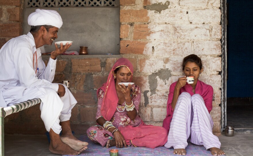 Durga and her parents relax in the courtyard of their two-room concrete block home.