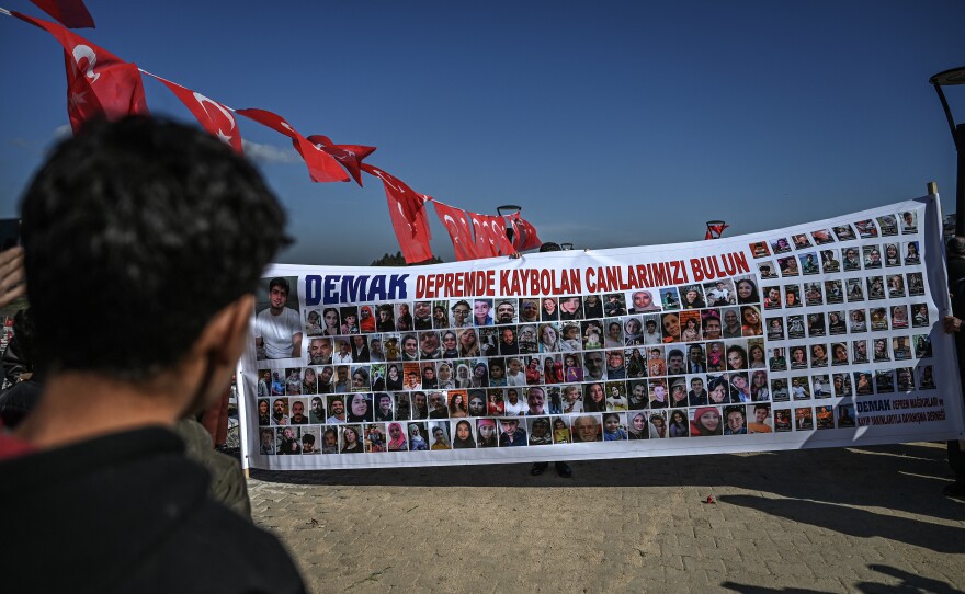 Relatives of missing people hold a banner with portraits and reading "Find our lives lost in the earthquake" at a cemetery during a gathering marking the first anniversary of a powerful earthquake that hit the region, in Antakya, southern Turkish Hatay province, on Tuesday.