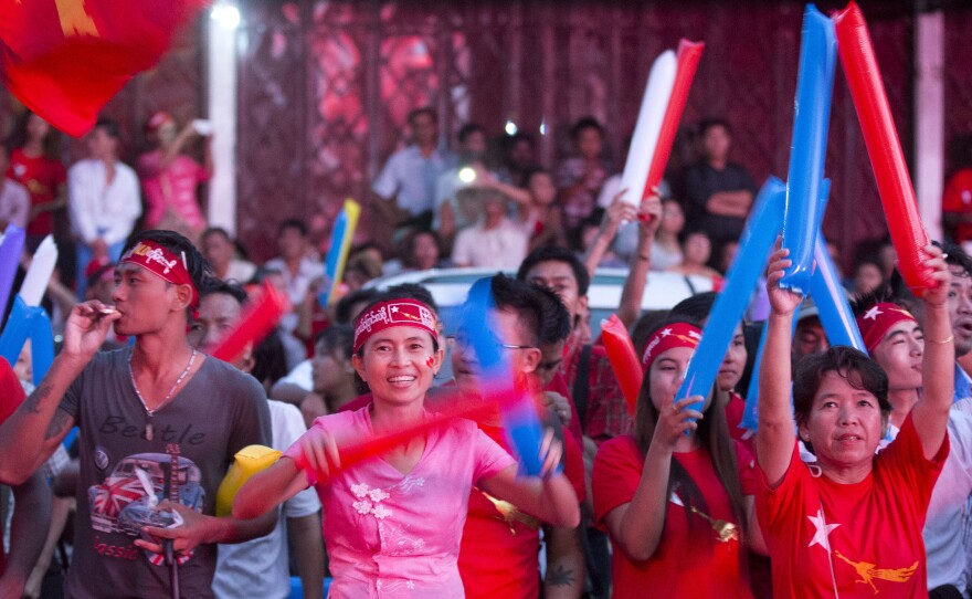 Supporters of Myanmar's National League for Democracy cheer as election results are posted outside party headquarters in Yangon, Myanmar's capital. Aung San Suu Kyi and other opposition leaders have tried to temper the celebrations, in anticipation of having to form a coalition — and contend with the military.