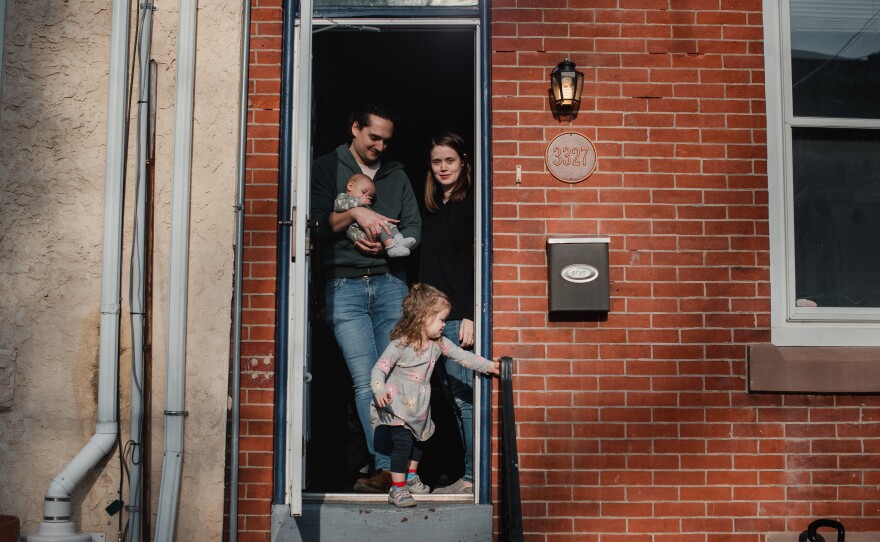 Jacob Griswold-Moran (left) and Katherine Moran stand with their children, Felix and Amelia Griswold-Moran, at their home on March 24. Griswold-Moran, a software developer, is now working from home while Moran, a speech pathologist, is on her maternity leave.