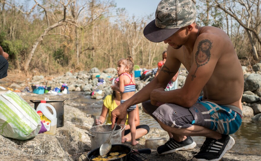 Luis Fernandez, 27, fries plantains over firewood on the banks of the Calabaza River.