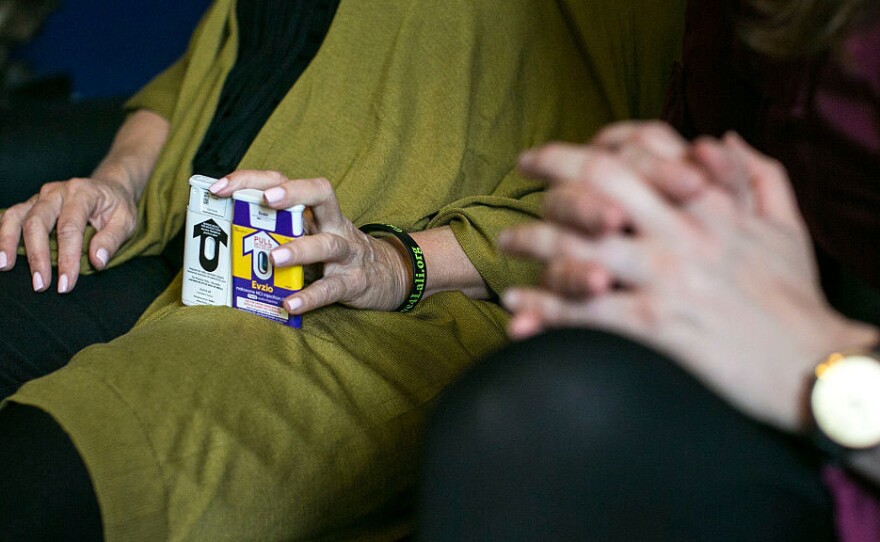 A woman lobbying Congress holds two versions of naloxone which can be used to reverse an opioid overdose.