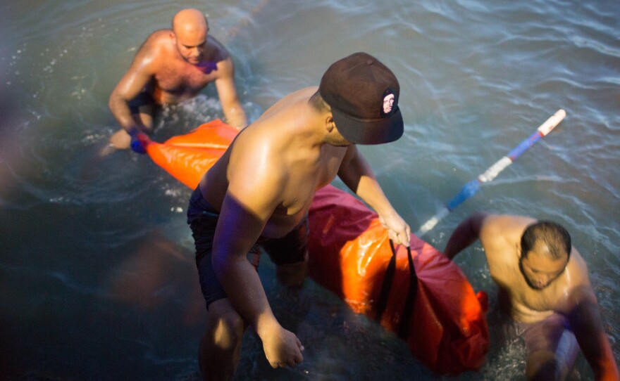 Rescuers remove the body of a migrant after their boat sank off the coast of in Zuwara, Libya, on Thursday.