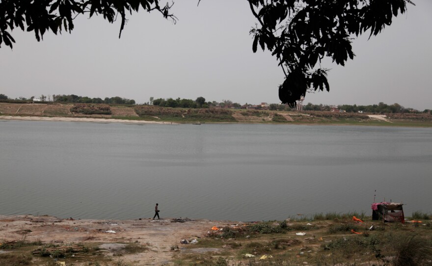 A man walks by the banks of the Ganges River in the town of Chausa in the largely impoverished northern Indian state of Bihar. The ashy remains are from funeral pyres — this is where Hindu residents cremate their loved ones, before submerging their ashes in the river. Residents say here, during the pandemic, as deaths surged, corpses washed up here over a period of six weeks.
