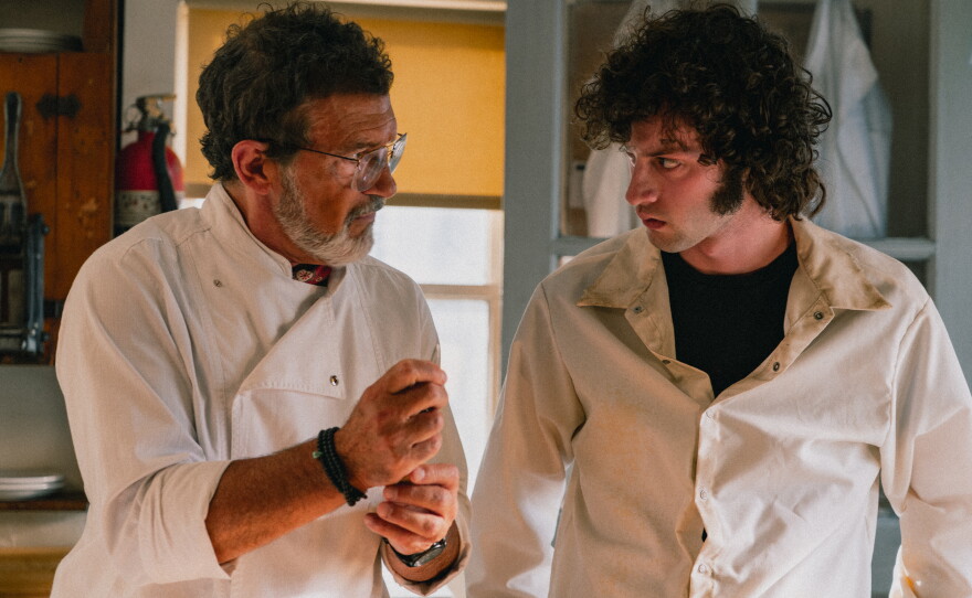 A restaurant's head chef portrayed by Antonio Banderas (left) takes under his wing a 19-year-old Anthony Bourdain, played by Dominic Sessa (right), in Tony.
