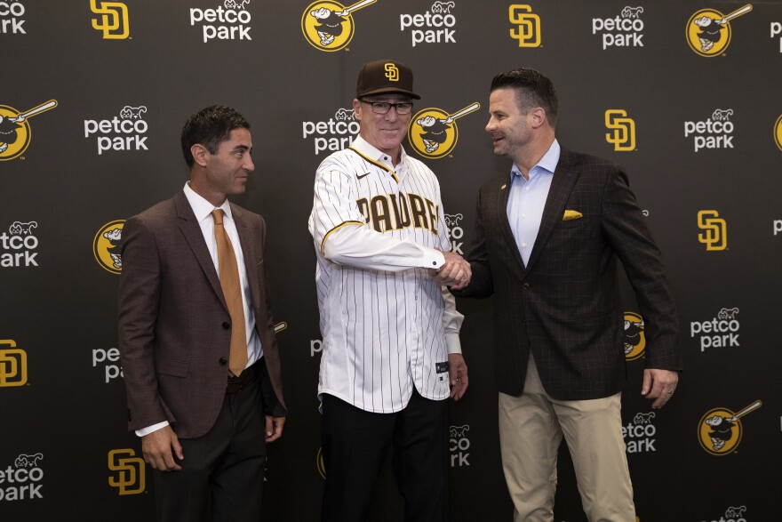 New San Diego Padres baseball team manager Bob Melvin, center, shakes hands with Padres CEO Erik Greupner as general manager A.J. Preller looks on during a news conference at Petco Park, Nov. 1, 2021.