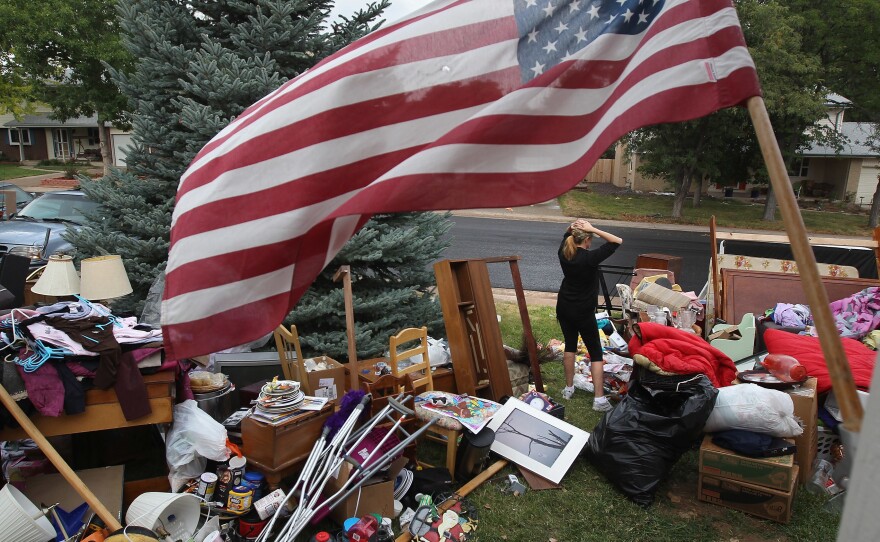 Julie Holzhauer stands among her family's possessions after being evicted from her home in Centennial, Colo., in 2011.