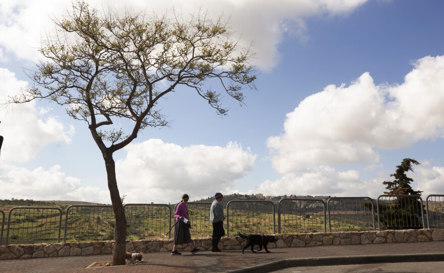 In this file photo from 2021, two women walk in the West Bank Jewish settlement of Efrat.