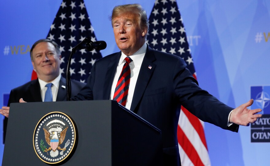 President Trump said Thursday that he has succeeded in getting U.S. allies to pledge more money for the alliance. Secretary of State Mike Pompeo looked on at a news conference after the NATO summit in Brussels.