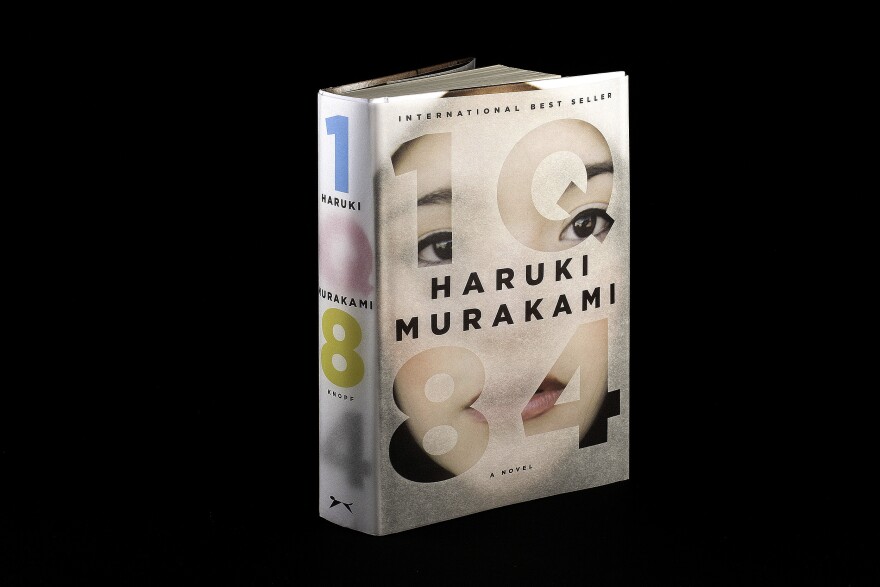 1Q84 by Haruki Murakami: "This epic, complex story begins when a woman named Aomame in 1984 Tokyo has a revelation that she has entered a universe parallel to our own. She calls it 'Q' for question, and in Japanese, Q rhymes with 9. I wanted to represent these two planes of existence with the book's jacket and its paper binding underneath."