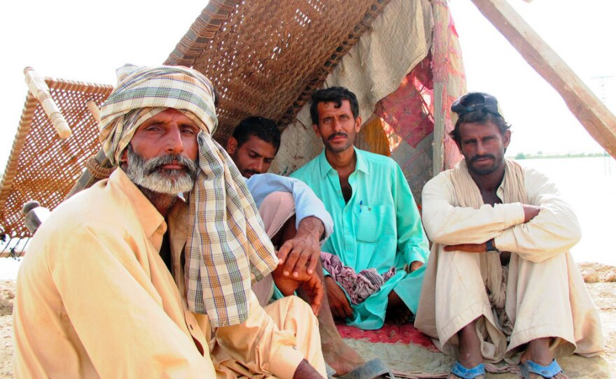 Zurif Kar, Hafiz Ullah, Abdul Majid and Sherun Kardarbush take shelter on top of the levee that has -- so far -- saved the city of Shahdadkot from the raging floodwaters.