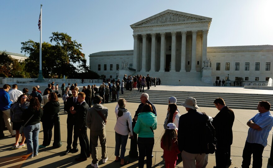 Visitors stand in line to watch arguments on the first day of the new term of the U.S. Supreme Court in Washington on Monday. On Tuesday, the court will take up the case of Gregory Holt, who argues that Arkansas prisoners like himself should be allowed to wear short beards.