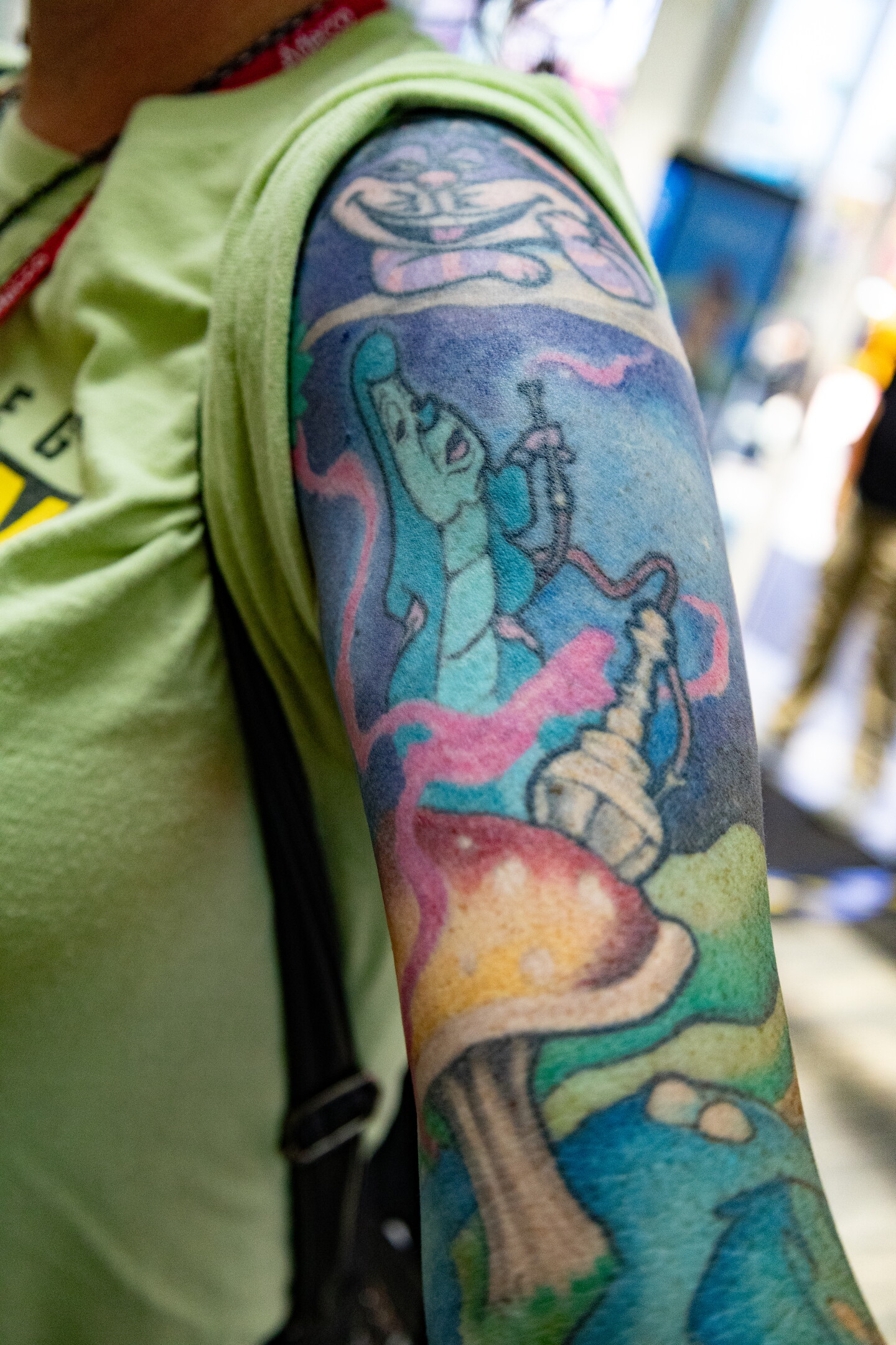 A Comic-Con attendee displays an "Alice in Wonderland"-inspired tattoo of the Cheshire Cat and Caterpillar at Comic-Con, July 23, 2026.