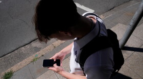 FILE - A teenage boy uses his phone in Sydney, Nov. 8, 2024.