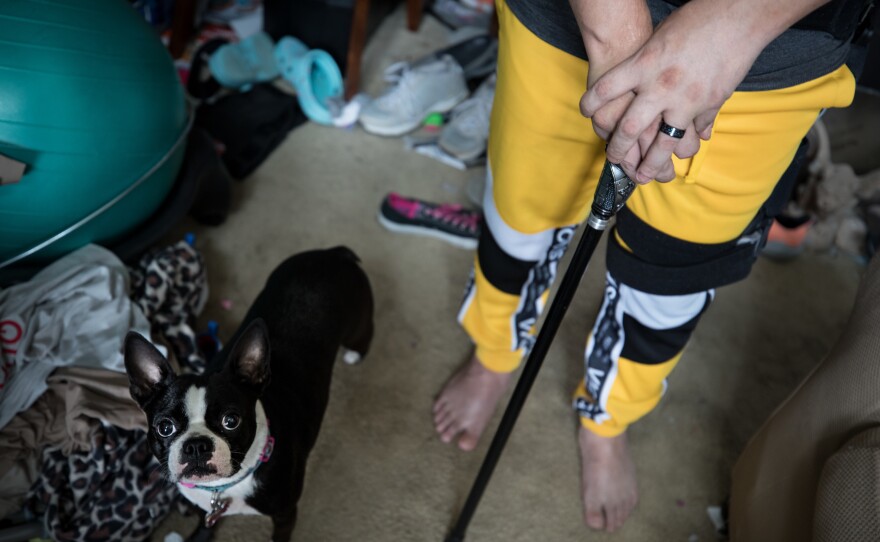 Marquette walks with the help of a cane and brace.