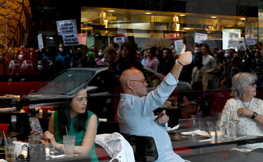 <strong>BOSTON</strong>: A man dining in a restaurant gives a thumbs-up to protesters who marched in support of reproductive rights.