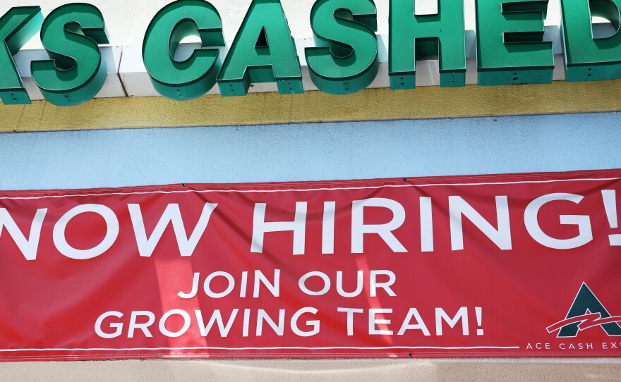 A 'Now Hiring' sign is displayed outside a check cashing shop in Los Angeles on June 2, 2023. Employers added 187,000 jobs in August, while the unemployment rate rose to 3.8%.