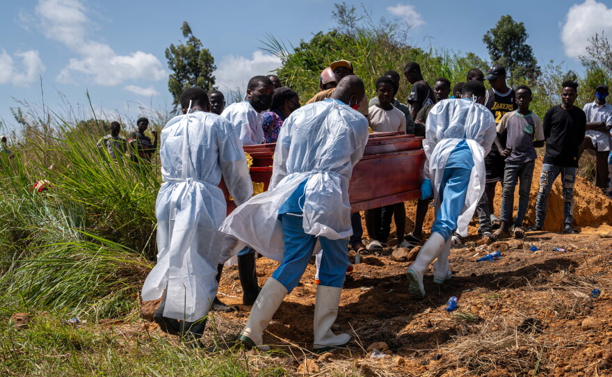 Health workers carry the coffin of a person suspected of having died from Ebola in the Democratic Republic on Congo.